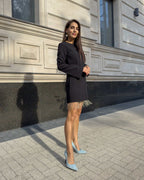 Rochie neagra scurtă cu franjuri din cristale și mâneci lungi, detalii decorative, purtată afară.