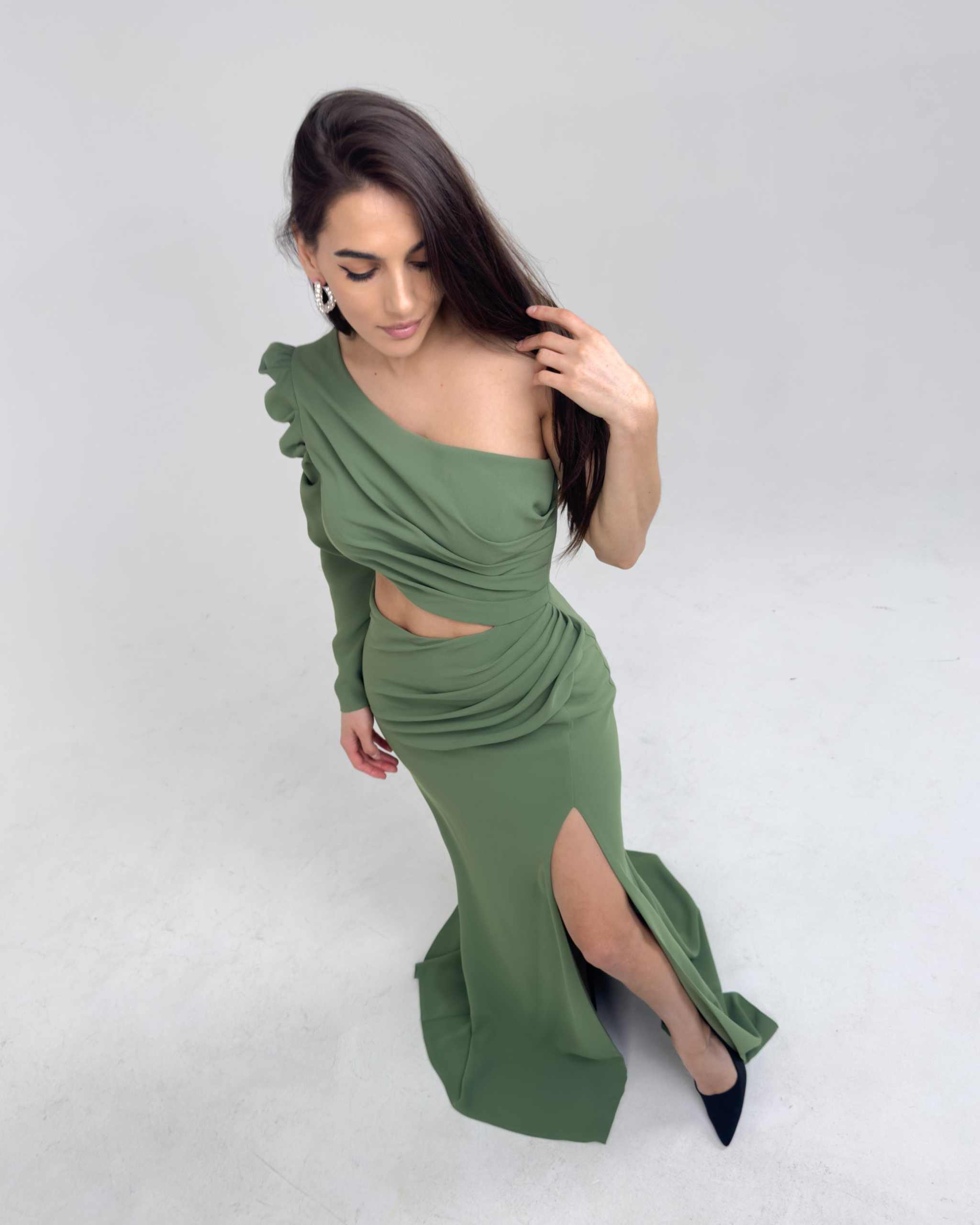 Rochie verde elegantă lungă cu o mânecă și șliț, decolteu pe un umăr.