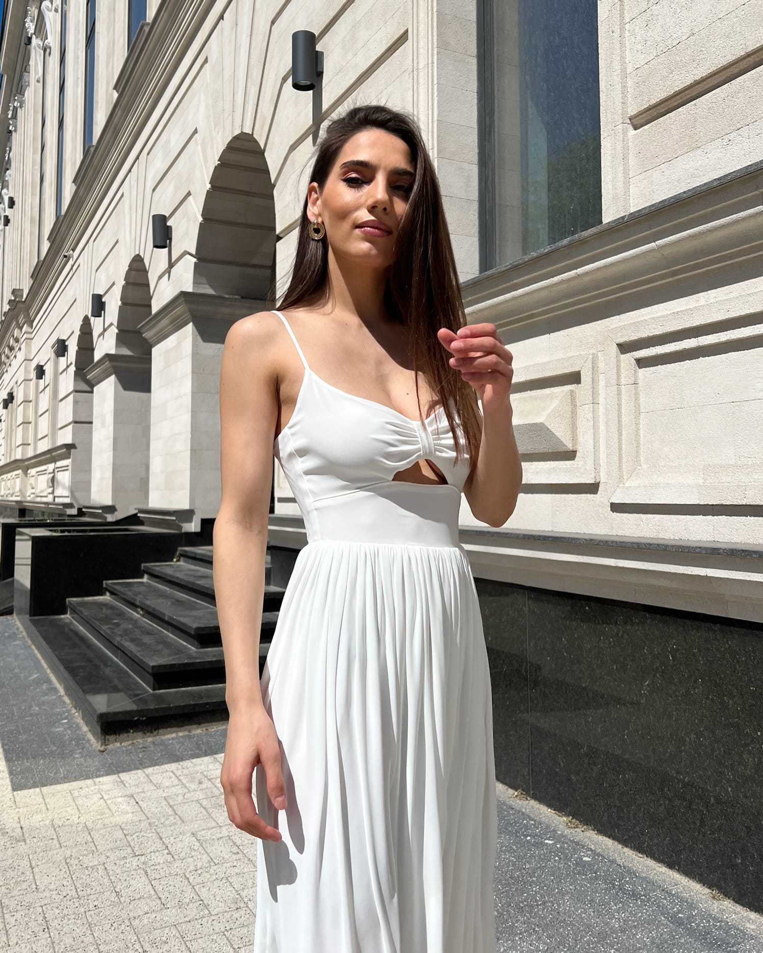 Rochie alba elegantă cu slit și bretele, lungime midi, evidențiază talia, cu fermoar la spate.