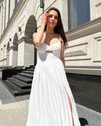 Rochie alba elegantă midi cu slit și bretele, accesorizată cu centură, cupe interioare și închidere cu fermoar la spate.