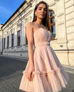 Rochie eleganta de ocazie roz deschis, scurtă, cu corset și fustă evazată.