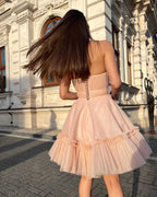 Rochie eleganta de ocazie roz deschis scurtă cu corset și fustă evazată.