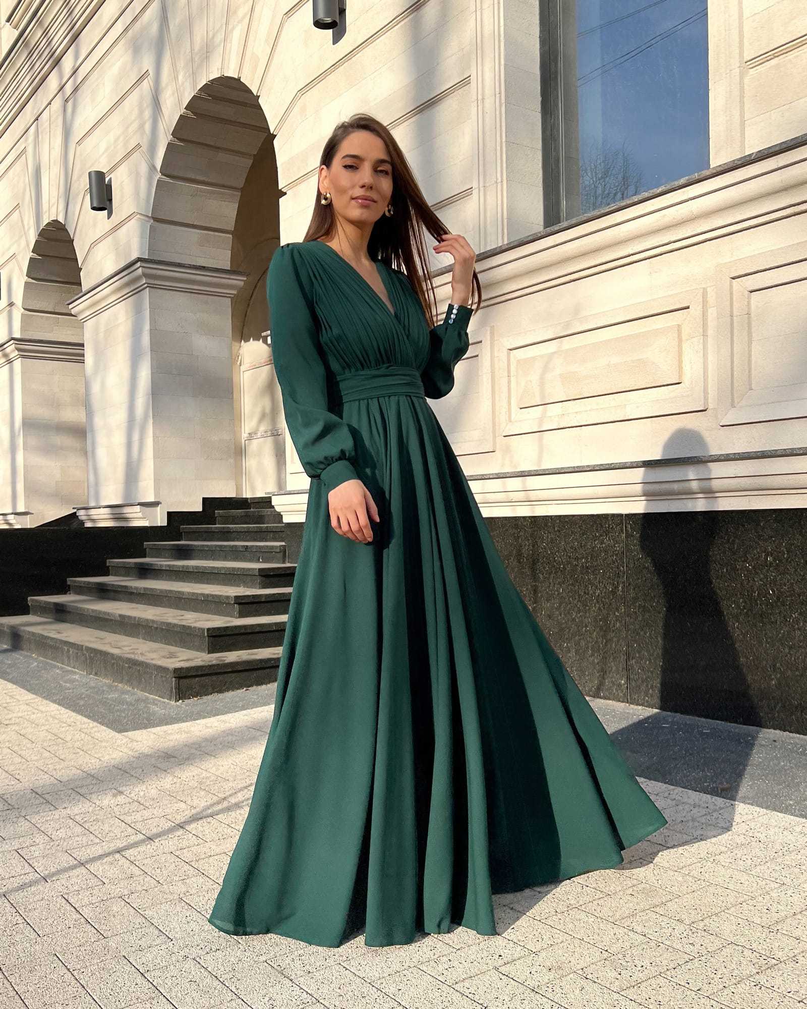 Rochie elegantă de seară lungă din voal verde cu decolteu în V și pliuri sofisticate.