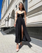 Rochie neagra lungă cu bretele și slit pe piciorul stâng.