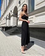 Rochie neagră cu bretele și slit, lungime 110 cm, model purtând mărimea XS.